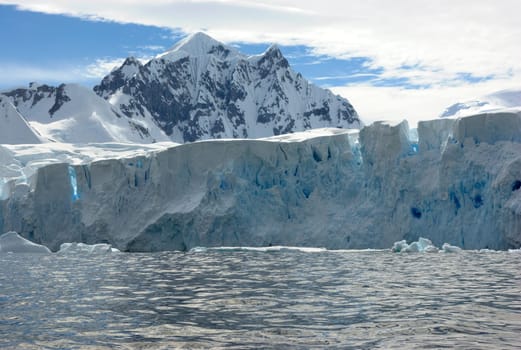 Huge iceberg in Antarctica, blue sky, azure water, sunny day.