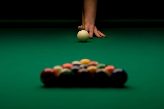 Person's hand ready to break billiard balls.