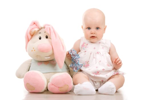 Pretty baby sitting next to giant toy, isolated on white