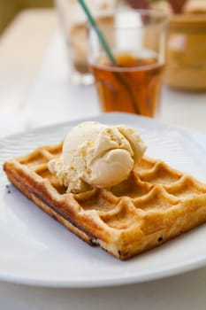 Delicious waffle with vanilla ice cream on a restaurant table