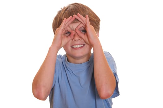 Happy young boy looking through a hole in his fingers