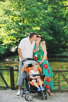 Happy young Family at park relaxing and have fun with pregnant woman