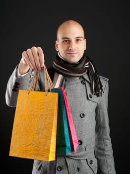 Young man with shopping bags in the dark