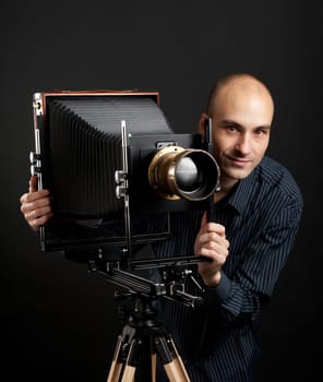 young man with retro camera in the dark