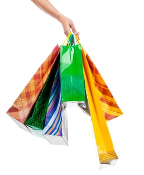 Female hand holding colorful shopping bags on white