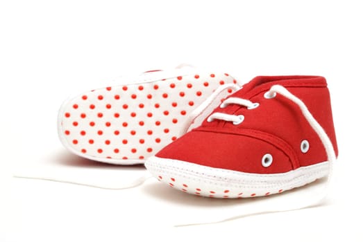 An isolated pair of red baby shoes for the newborn to wear.