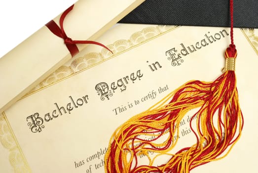 A diploma and grad hat represent a high achieving student in the field of education.