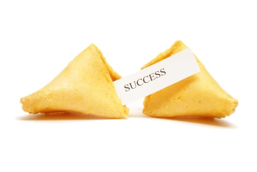 A cracked open fortune cookie stating the word success.