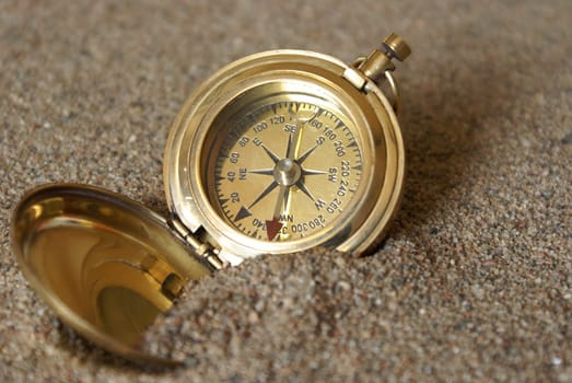 A conceptual image of a compass in the sand to amplify being lost.