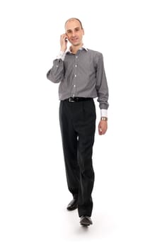 Portrait of happy businessman talking on mobile phone while walking - White background