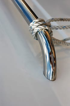 Ropes tied up on a bitt of a white boat