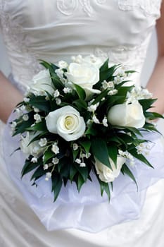 The bride holds a wedding bouquet