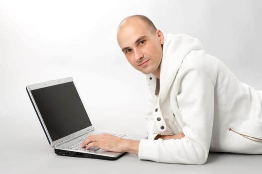 Portrait of a young man using a laptop, gray background