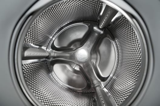 Inside washing machine with detailed view at the metallic drum part.