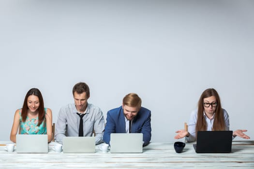 Business team working together at office on light gray background. all working on laptops. copyspace image