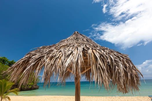 A straw umbrella on a beautiful tropical beach