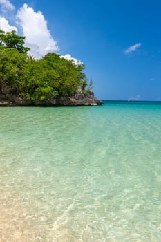 Beach on the tropical island. Clear blue water, blue sky. Beautiful vacation spot.