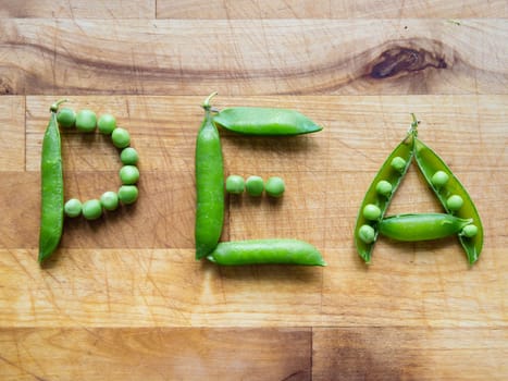 Word PEA created with peas on a wooden board
