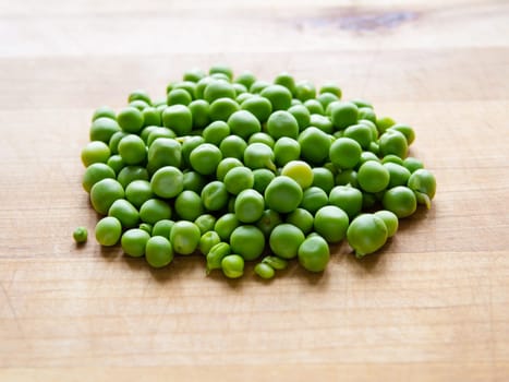 Pile of podded peas on wooden board