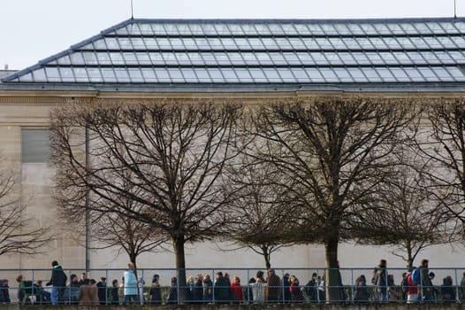 Paris,France – December 29,2013: A human snake waits outside the Musée d'Orsay art museum in Paris outside a glass roof for admission on December 29,2013 in Paris.