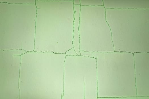 Cracks on wall. Scratches on green background. Old paint. Surface crack.
