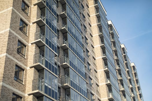 Windows in new building. Apartment building in city. New housing. Glazed balconies.