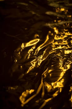 Golden texture. Wave of gold. Thin film. Crumpled surface.