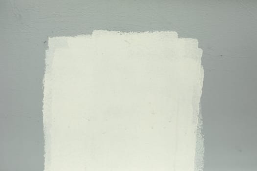 White paint on grey wall. Paint spot white. Smeared inscription. Poor wall painting.