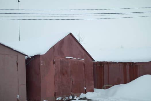 Garages in winter. Garages in snow. Roofs of houses in snow. Winter in Russia.