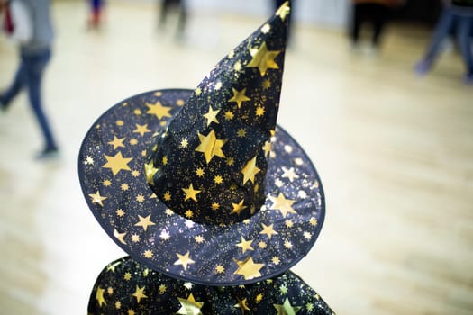 Wizard hat. Child at holiday. Cap on head. Details of children's play. Costume children's party.