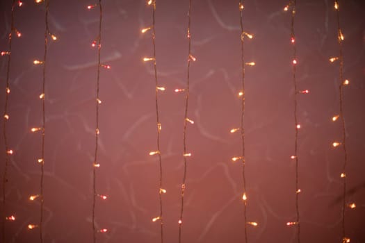 Pink garlands. Light bulbs on threads. Little lights in dark. Bright decoration.