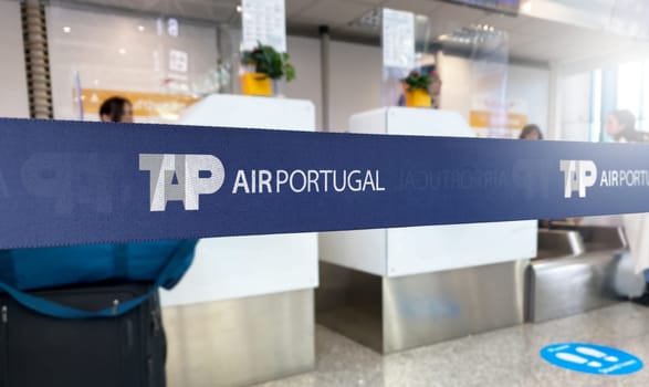 Lisbon, PT Jan 2023: Blue retractable belt barrier with white TAP Air Portugal logo. TAP Air Portugal is the portuguese flag carrier airline. Travel and airport security. Illustrative editorial