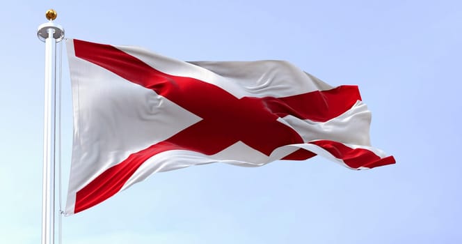 The state flag of Alabama waving in the wind on a clear day. Saint Andrew’s cross on a white background. 3D illustration render. Rippled textile