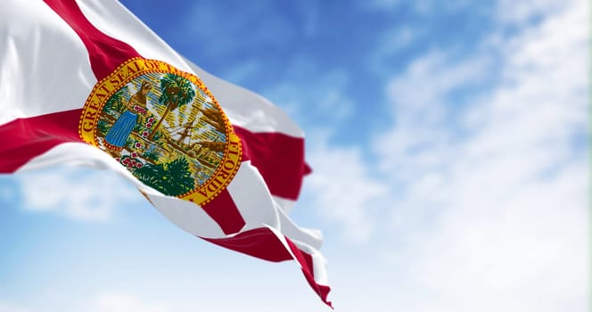 Close-up view of the Florida state flag waving in the wind on a clear day. Red saltire on white with the state seal in the center. 3d illustration render. Selective focus.
