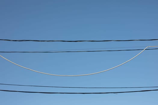 Wire on sky background. Electrical wires hanging. Communication links. Infrastructure in city.
