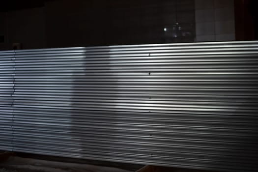 Steel fence at night. Fence in evening. Industrial zone. Metal sheet.