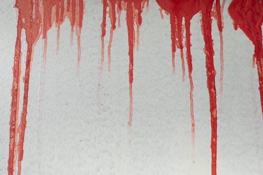 Red jets on wall. Paint flows down. Blood on surface. Vandalism on building details. Texture of current ink.