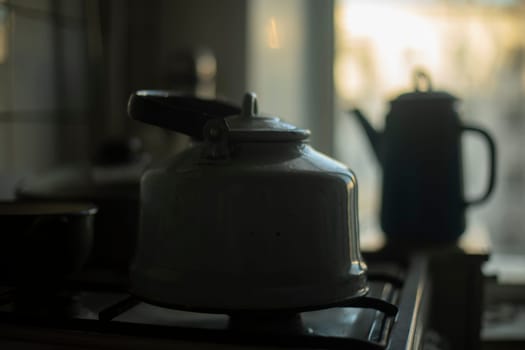 Kettle in kitchen. Simple kitchen in small apartment. Old kitchen items. Old-fashioned interior.