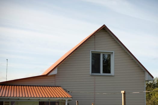 House in village. Window on second floor. Inexpensive house in countryside. Ridge roof.