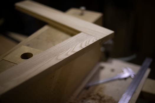 Manufacture of furniture in carpentry workshop. Board without processing. Corner is made of wood. Creation of strong joint from boards.