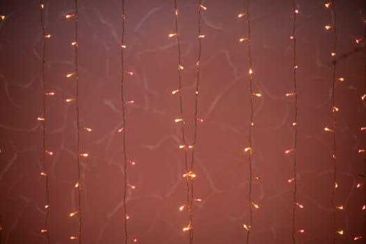 Pink garlands. Light bulbs on threads. Little lights in dark. Bright decoration.