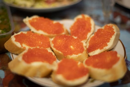 Bread with red caviar. Russian food. Bread and butter on table. Snack for holiday.