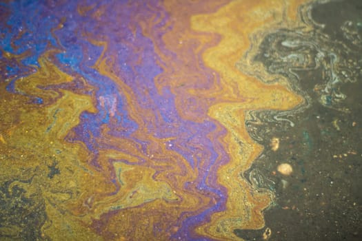 Spot gasoline. Puddle of fuel. Acid colors. Texture bright liquid.
