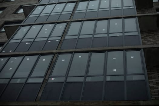 New windows in building. Balconies in house. New residential building. Details of construction.