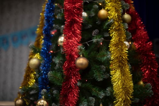 Toys and garlands for Christmas. Decorations on Christmas tree. Garlands on tree. Details of holiday.