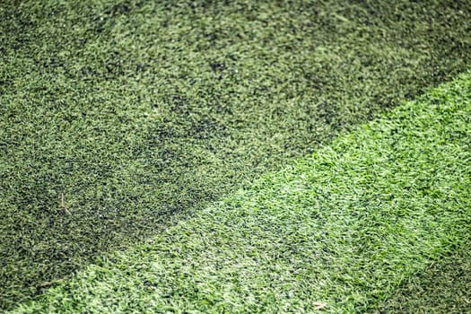 Football field coverage. Green background of artificial grass. Stadium details. Plastic carpet.