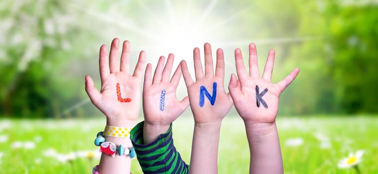 Children Hands Building Colorful English Word Link. Sunny Green Grass Meadow As Background.