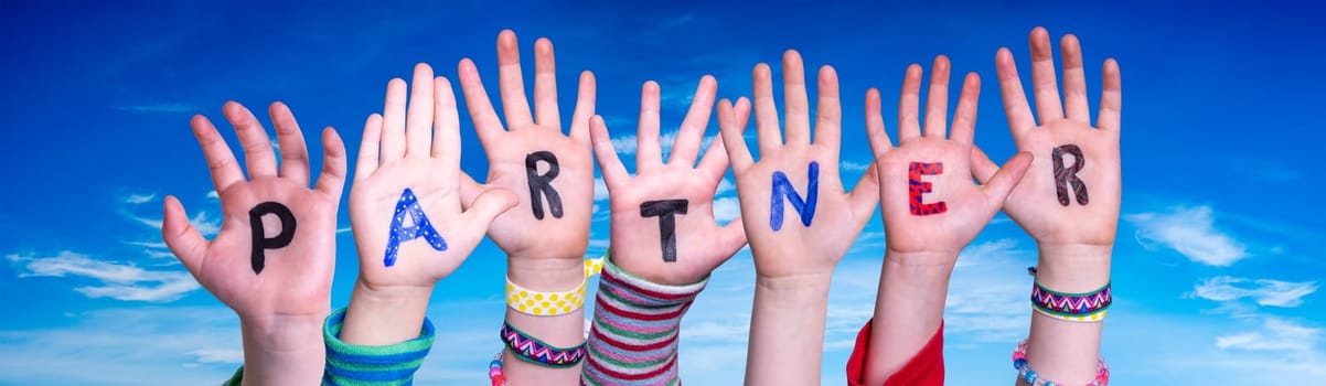 Children Hands Building Colorful English Word Partner. Blue Sky As Background