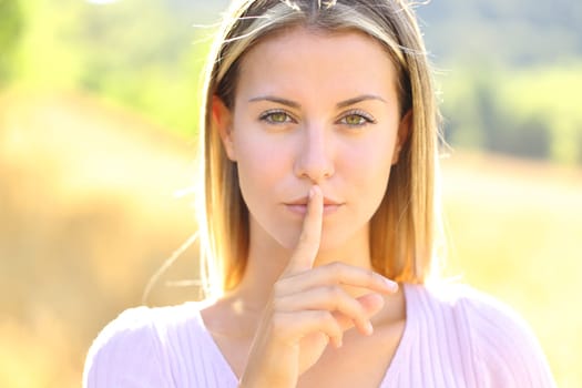 Front view portrait of a beautiful woman asking for silence in nature