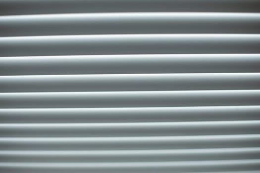 Blinds are white. Window in afternoon. Protection from light. Blinds on window. Simple form.
